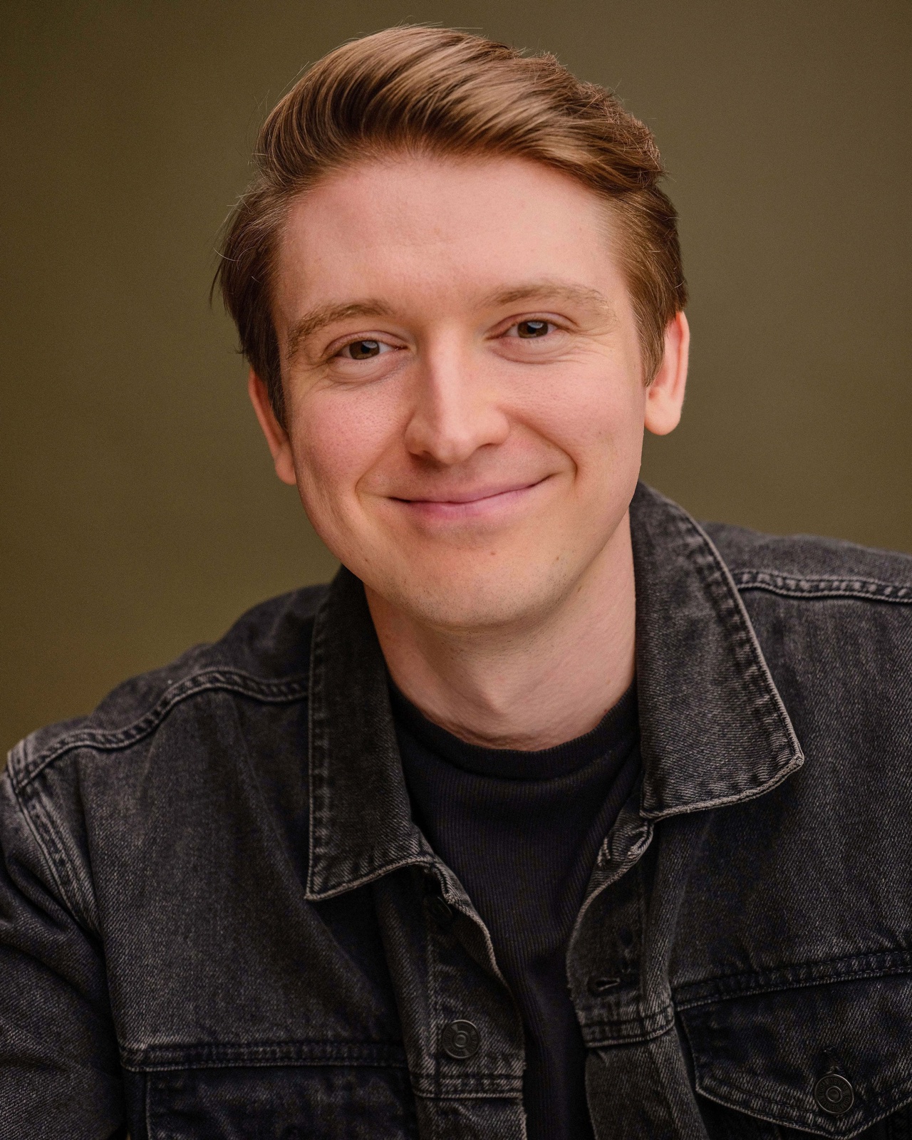 Andrew Miles smiling, wearing a dark denim jacket