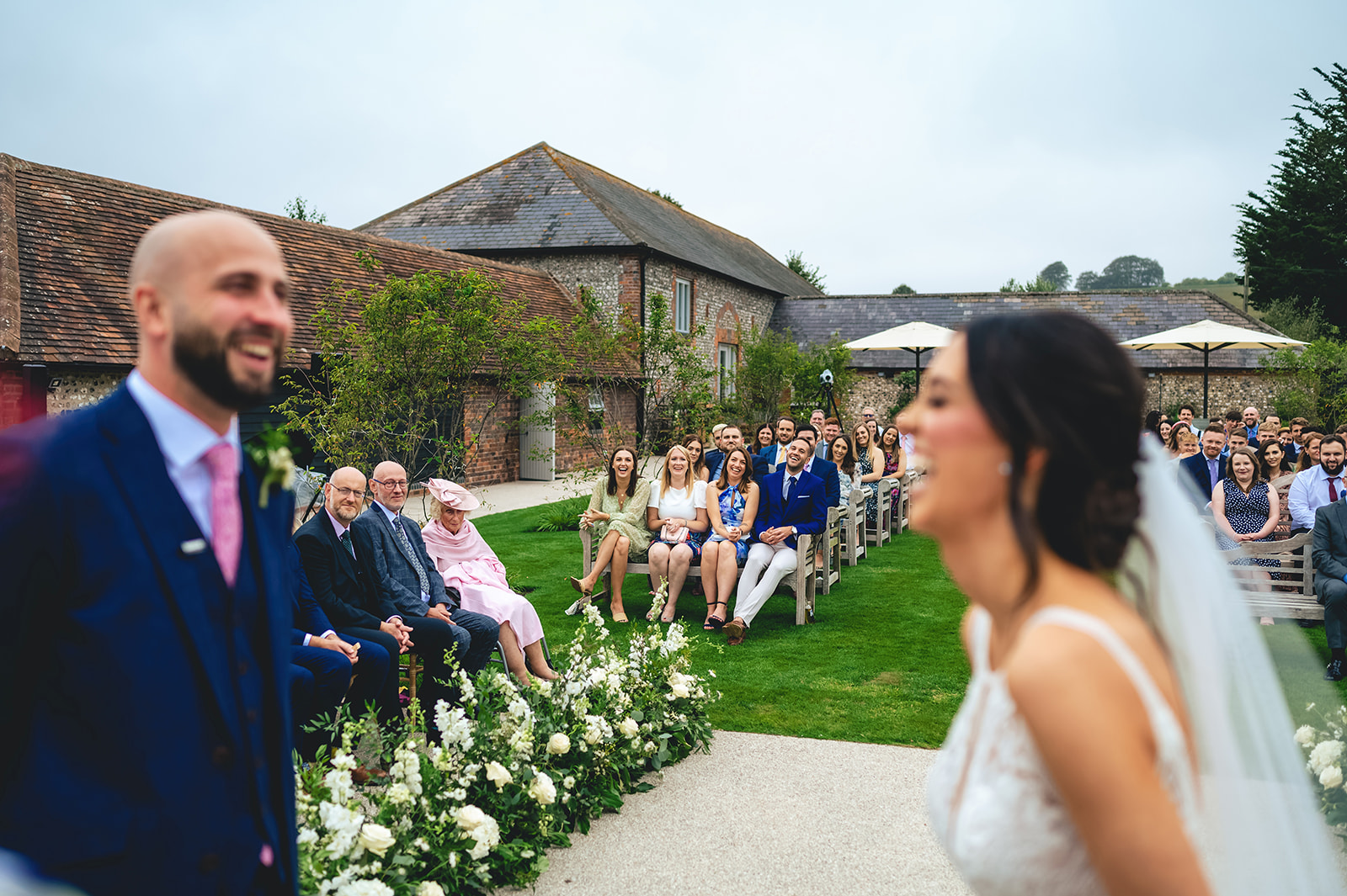 Guests laughing as Emma and Steve share a moment during their outdoor ceremony