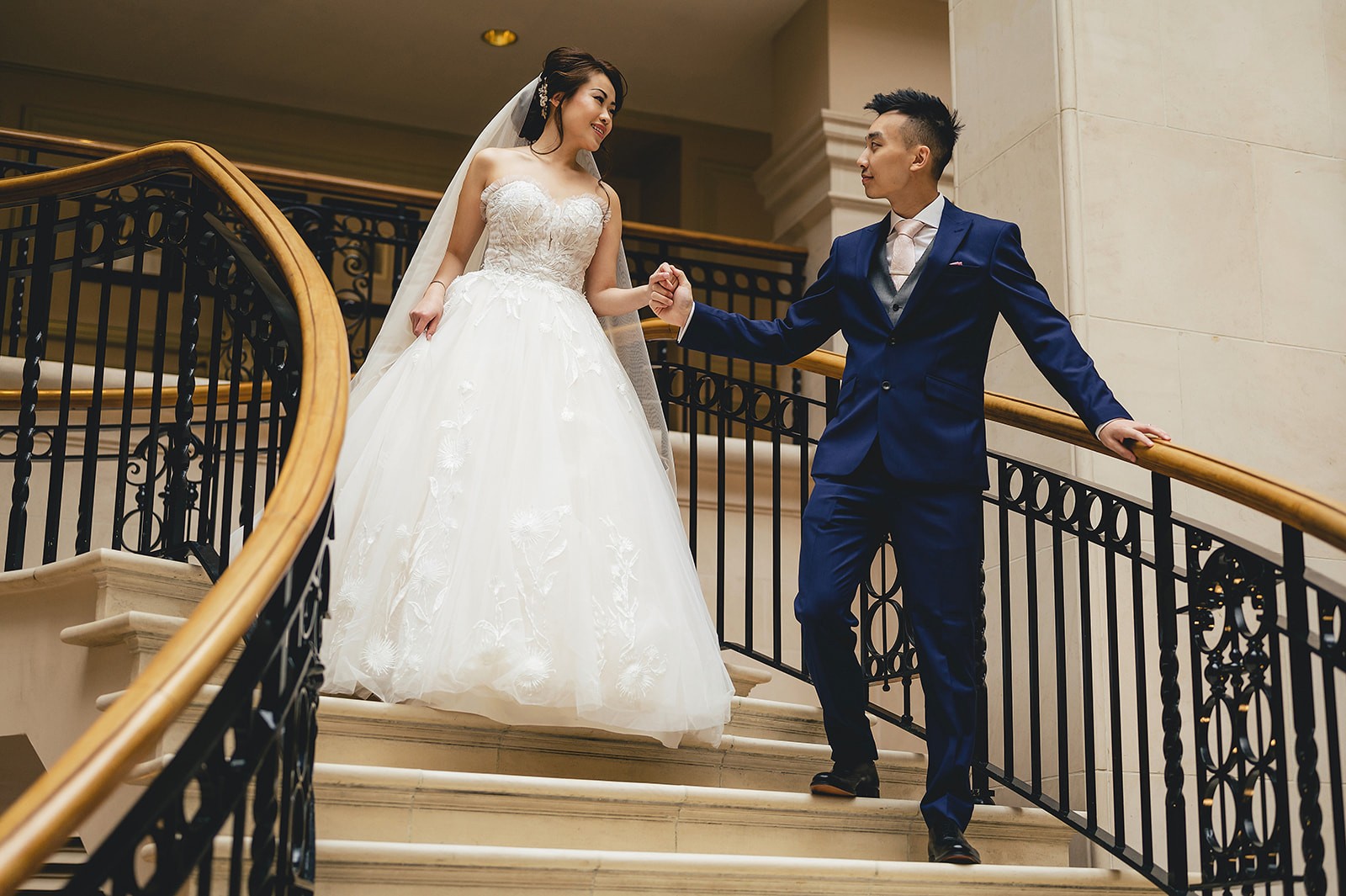 A couple holding hands on the staircase at The Landmark London