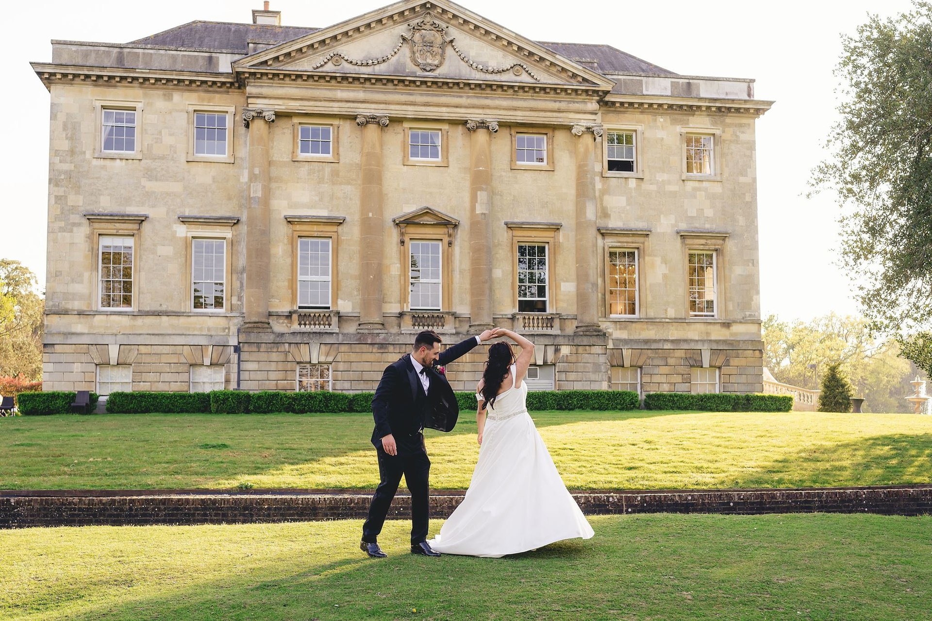 A couple dancing outside an elegant country house