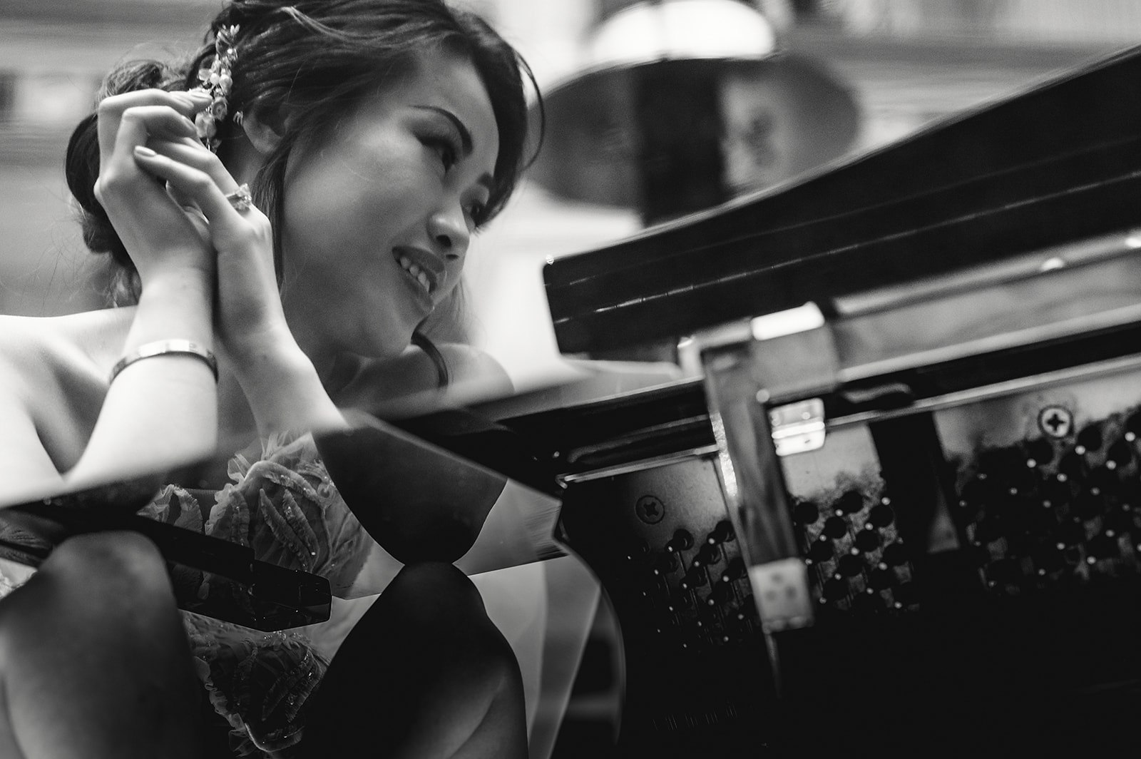 A bride reflected in a grand piano in black and white