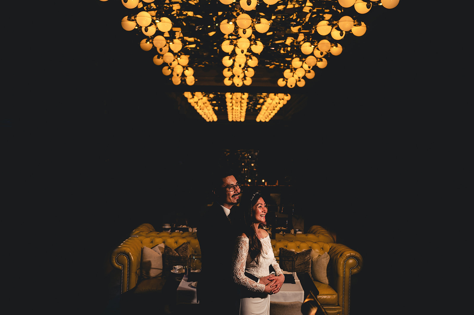 Maria and Henry beneath glowing chandeliers at the Rosewood Hotel