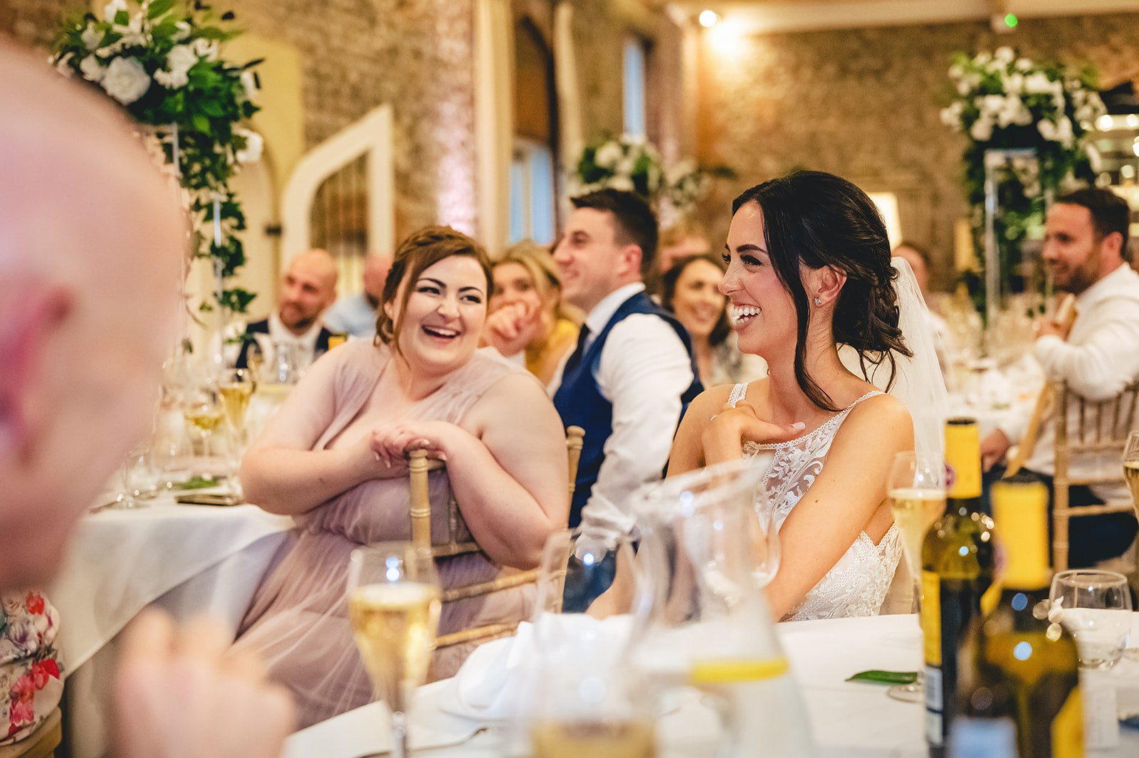 A bride and guest laughing at the reception