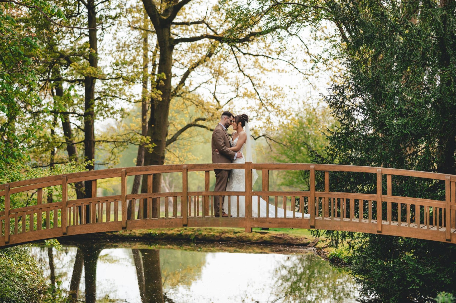 A couple embracing on a bridge among the trees